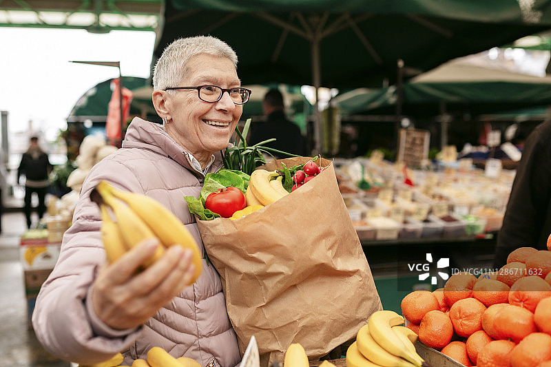 快乐的白人老女人在农贸市场购物图片素材
