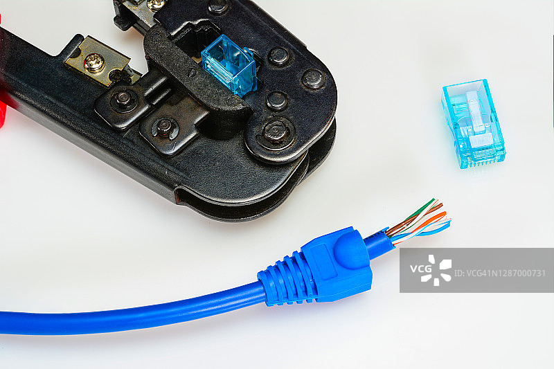 RJ45连接器，蓝色引导的rj-45插头，跳线和压接工具的家庭互联网连接。家庭网络概念，特写。图片素材
