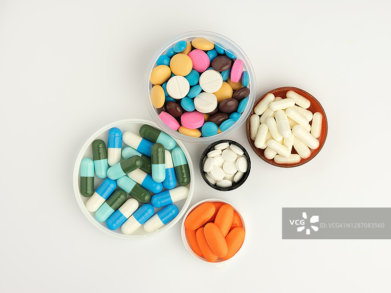 圆形容器内的彩色药品，白色背景，俯视图图片素材