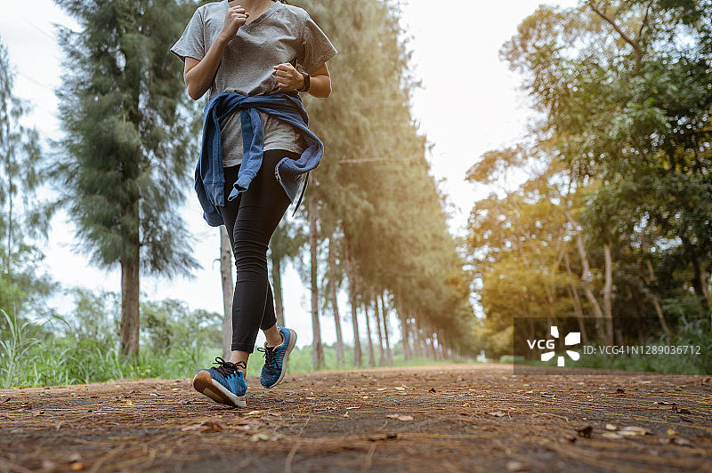 一名年轻女子在自然公园跑步。图片素材