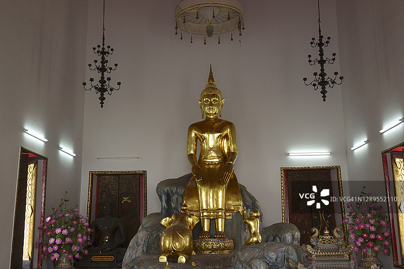 近距离观看曼谷卧佛寺的金色坐佛雕塑图片素材