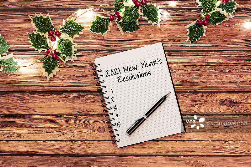 “2021年新年决心”写在圣诞彩灯笔记本上图片素材