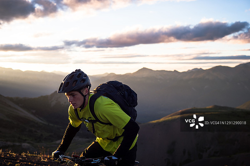日出时骑山地车的人在高山小道上骑行图片素材