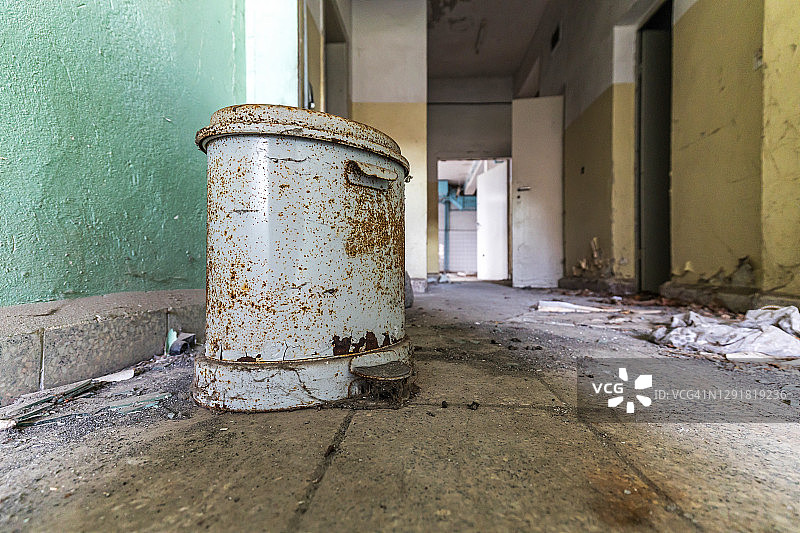 废弃建筑里的肮脏走廊和生锈的垃圾桶图片素材