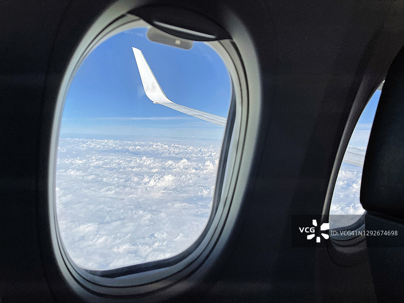 飞机窗口，看飞机机翼，蓝天和白云图片素材