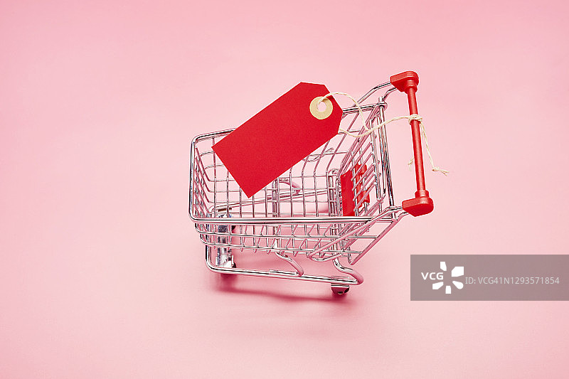 一个小购物车的静态生活与粉红色的背景空白红色价格标签，网上购物图片素材