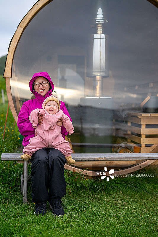 挪威吉姆斯øy，妈妈和宝宝坐在桑拿房前图片素材