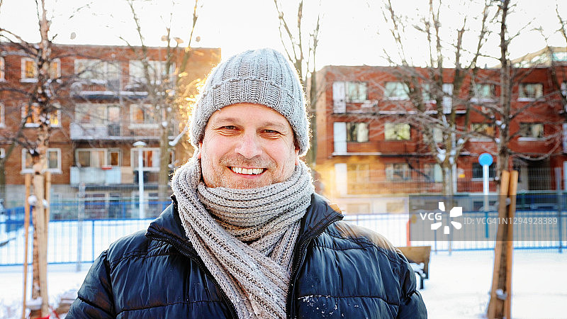 快乐成熟的男人，为深冬城市肖像充分微笑的背光日落图片素材