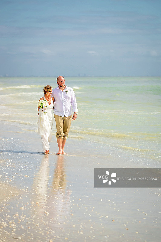 新娘和新郎沿着海边散步图片素材