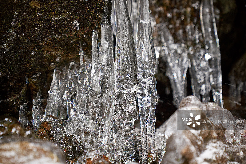 岩石上的冰柱和冬天森林里的冰。图片素材