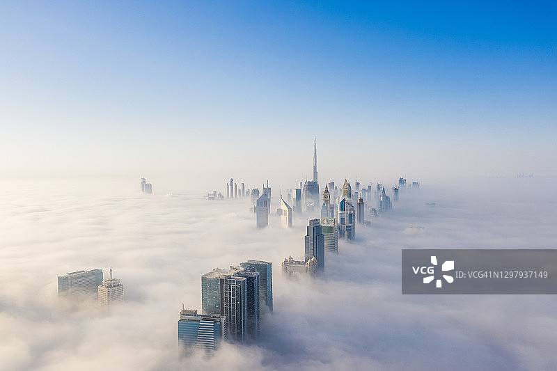 鸟瞰图的迪拜框架和天际线覆盖在浓雾在冬季图片素材