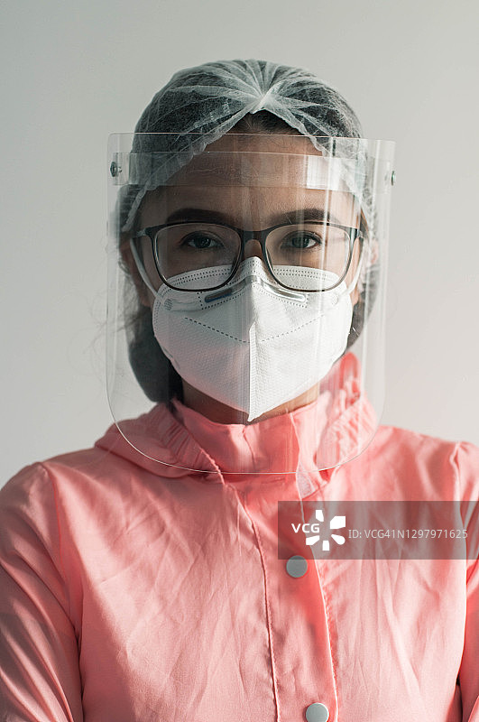 一幅东南亚女医生的肖像，穿着防护服、面罩和面罩，背景是白色图片素材