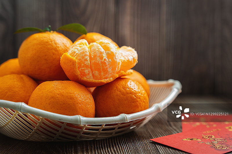 深木桌上的橘子和红包。中国新年。图片素材