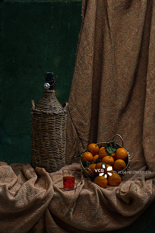 静物-大稻草盖瓶，葡萄酒杯和橙子图片素材