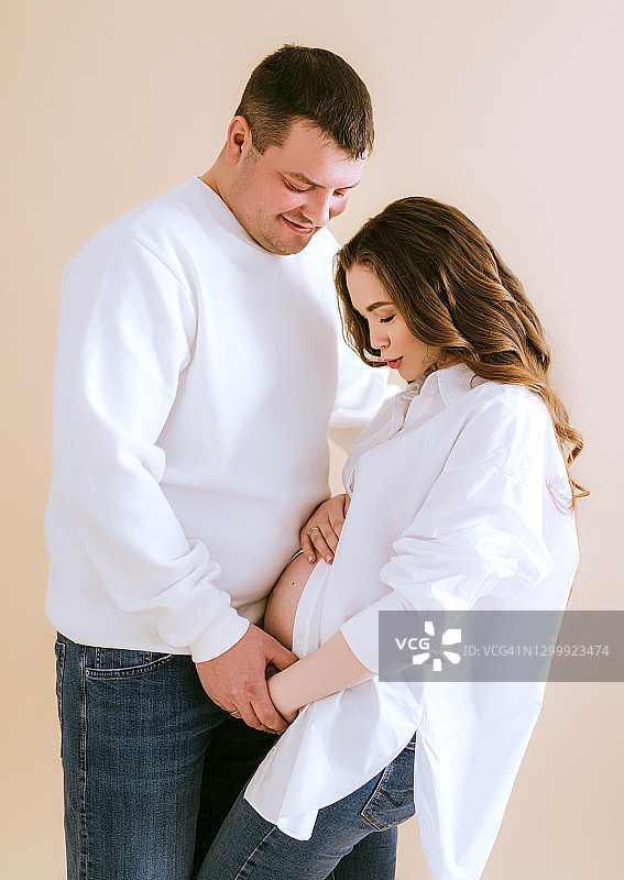年轻的怀孕夫妇等待着宝宝，幸福的怀孕未来的父母在一起图片素材