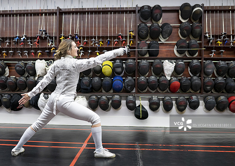 女子在健身房穿着击剑服练习图片素材