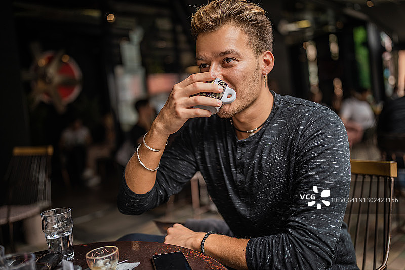 年轻英俊的男人在喝咖啡休息图片素材