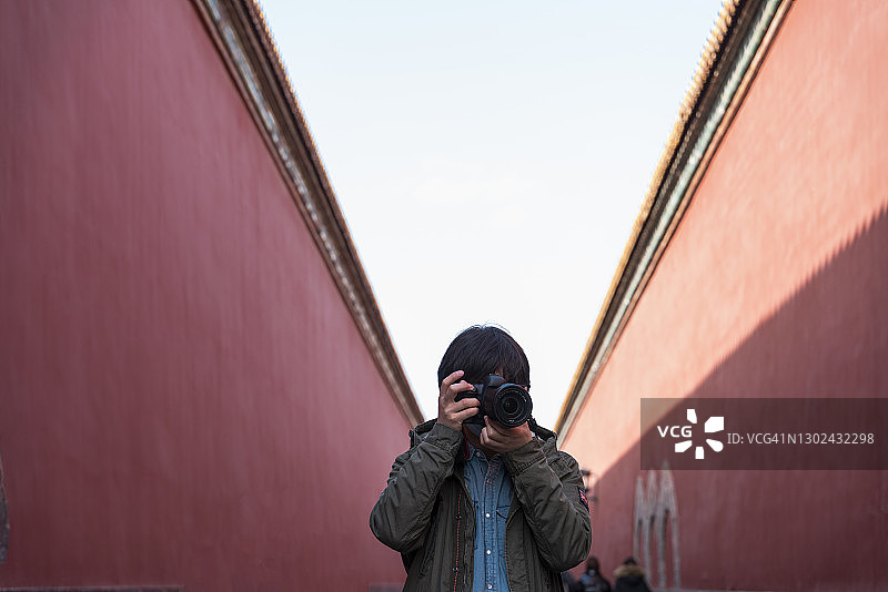 一个旅人正在紫禁城使用相机图片素材