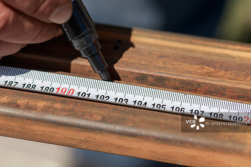 工人用测量工具、卷尺和记号笔测量金属图片素材