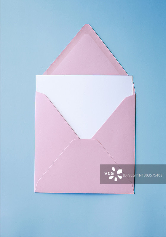 粉红色信封与白色空白卡片在蓝色背景图片素材