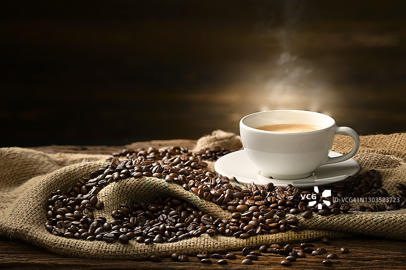 咖啡与烟和咖啡豆在麻袋上的旧木制背景图片素材