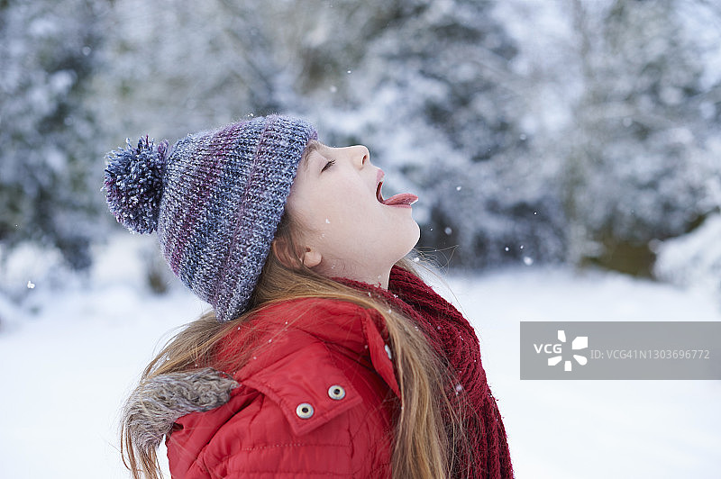 一个用舌头接雪花的小女孩图片素材
