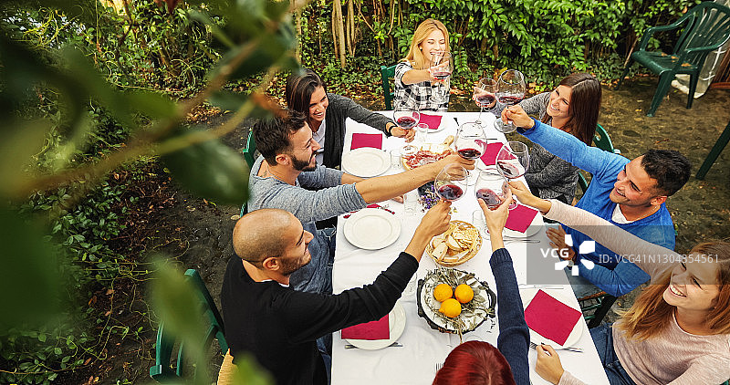 朋友们聚在一起吃饭、喝红酒:干杯图片素材