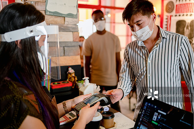 咖啡店的咖啡师戴口罩，封锁，隔离，冠状病毒，回归正常概念图片素材