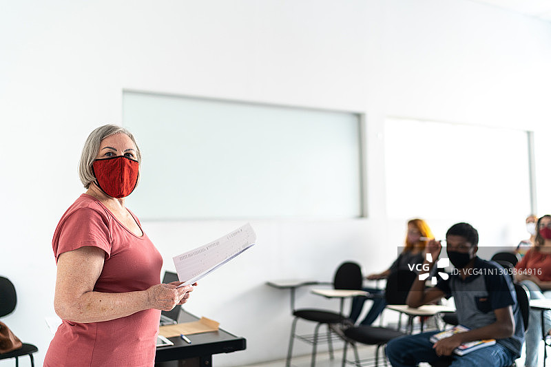 一个老师在教室里戴口罩的肖像图片素材