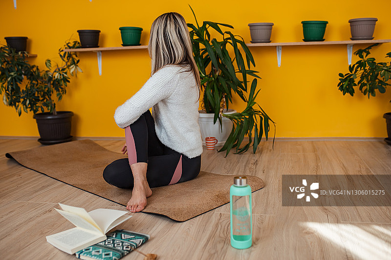 柔韧活跃的女人练习瑜伽在她的公寓图片素材