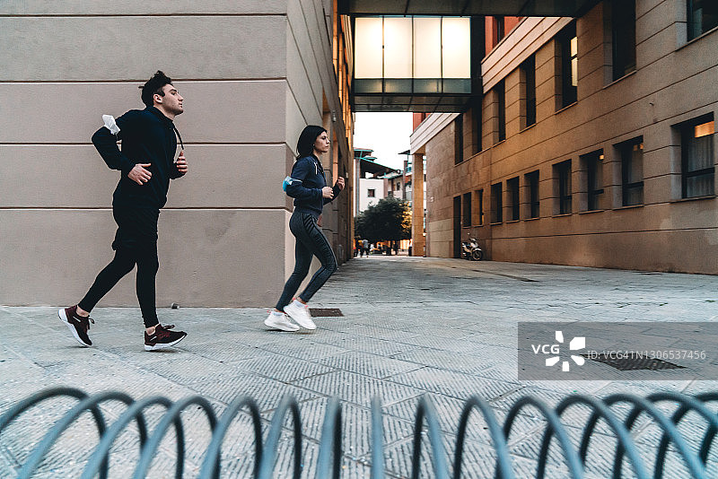 一对年轻夫妇在城市里一起跑步图片素材