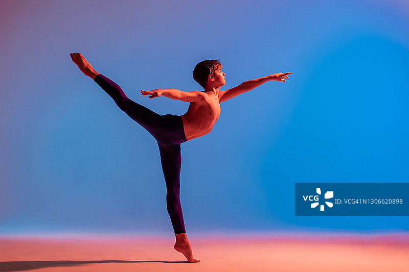 十几岁的芭蕾舞演员在彩光下赤脚跳舞。图片素材