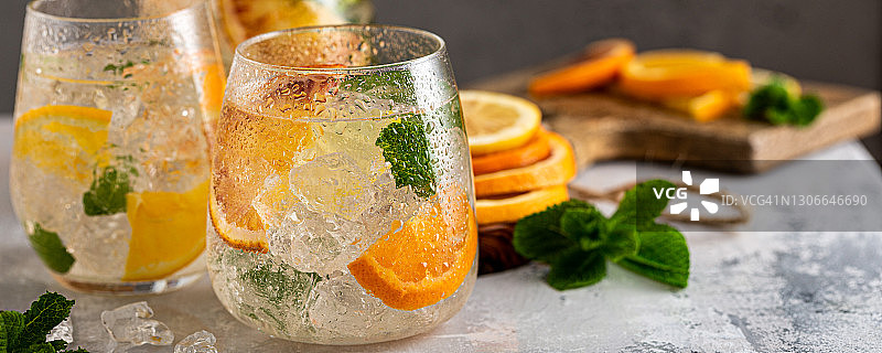 加碎冰，薄荷叶和橙子的新鲜鸡尾酒。夏日冷饮概念与文案空间、横幅图片素材
