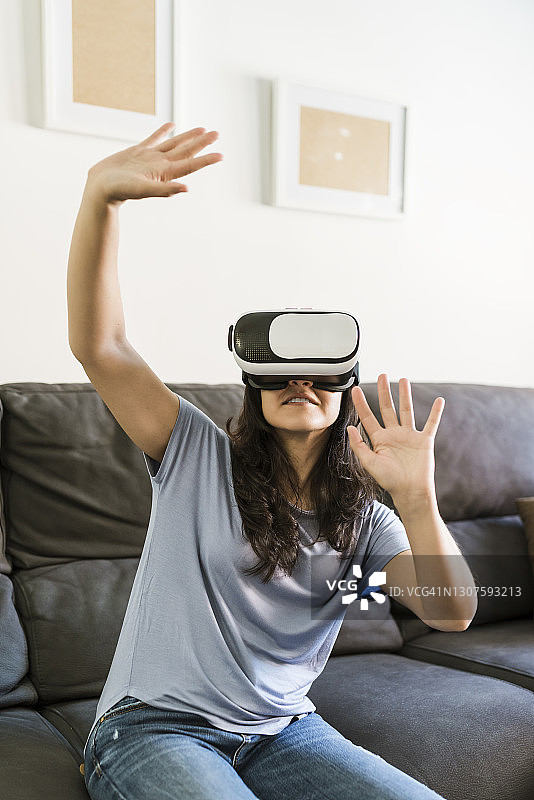 女人在家里用VR眼镜打手势图片素材
