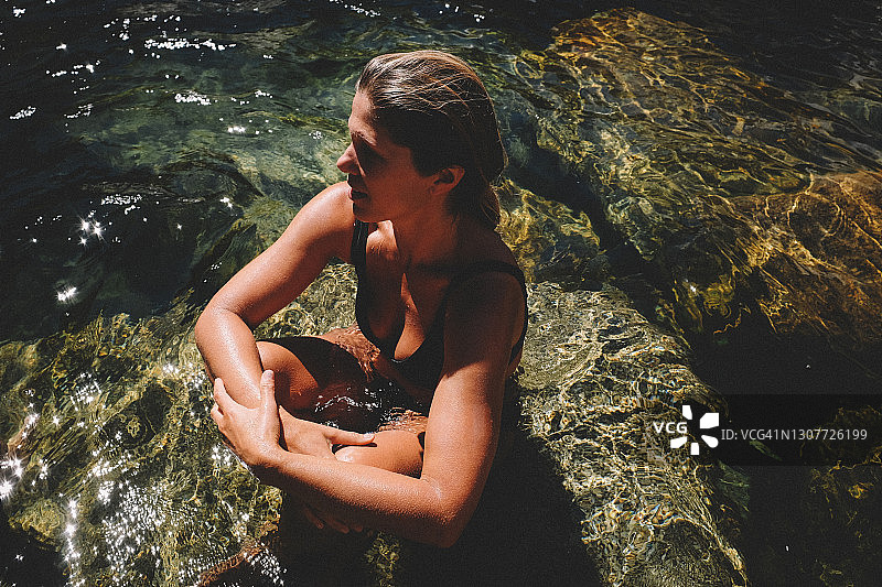 夏天，一名妇女坐在尤巴河清澈的河水中图片素材