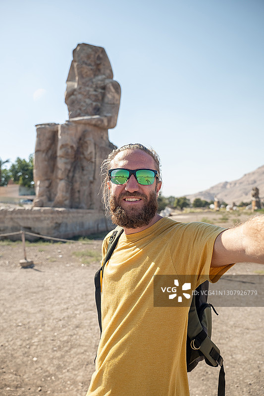 一名男子在埃及旅行，与埃及神像自拍图片素材