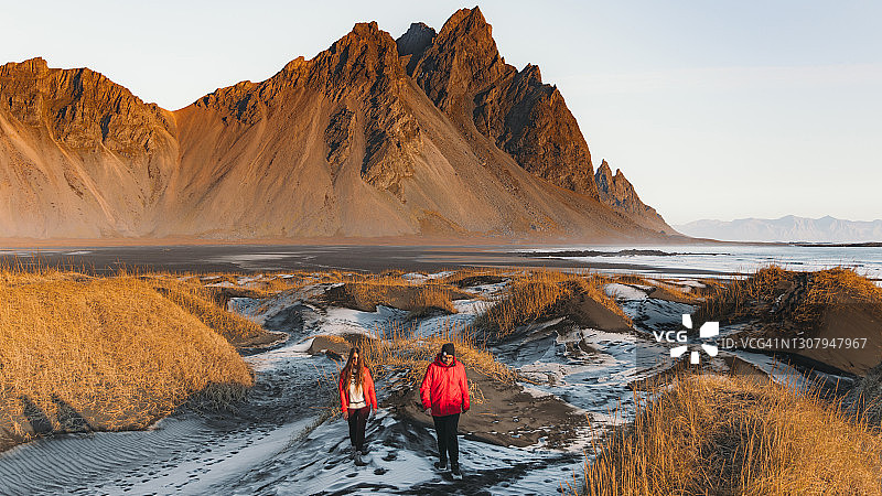 年轻的游客夫妇探索风景优美的荒野景观在冰岛在明亮的日出户外图片素材