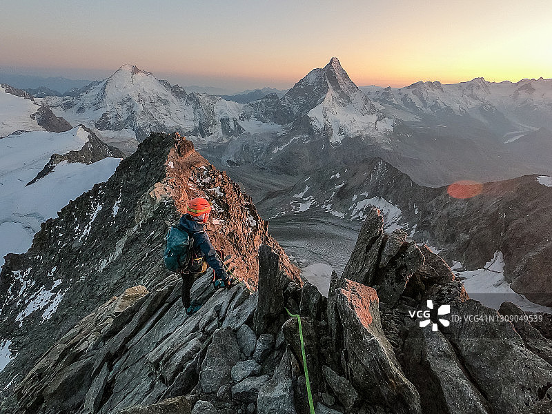 用绳索攀爬高海拔山脉。从山顶欣赏风景的人图片素材