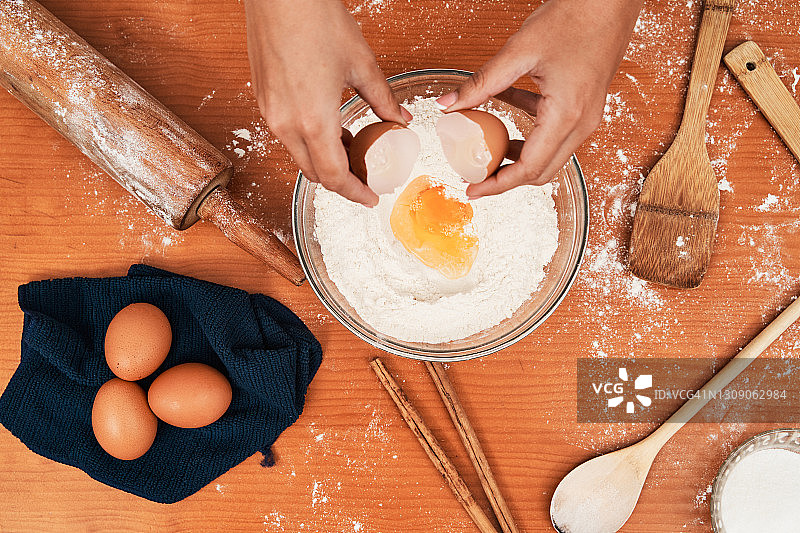 厨师将鸡蛋加入面团原料中图片素材