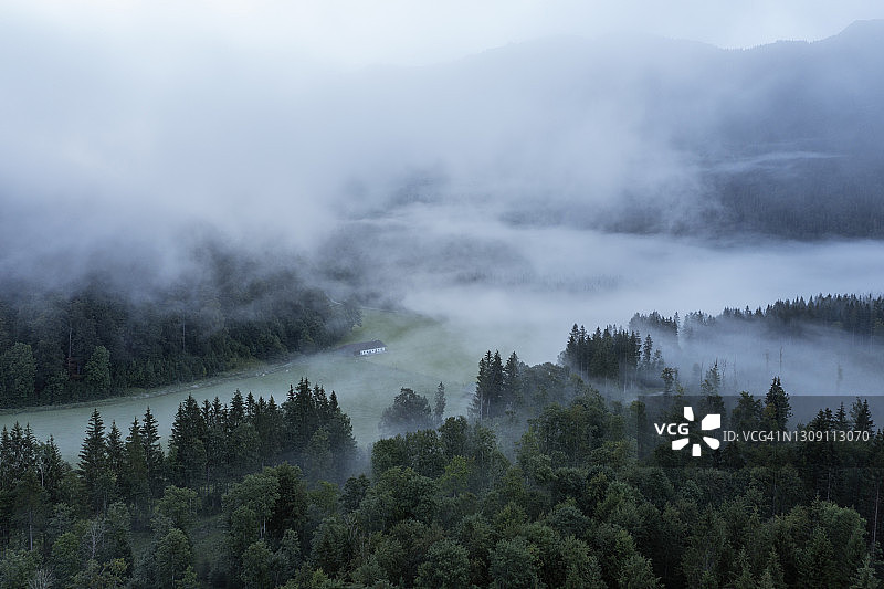 鸟瞰图的雾景观与森林和草地，秋天的早晨。上巴伐利亚，Bad Tölz-Wolfratshausen，巴伐利亚阿尔卑斯山，巴伐利亚，德国。图片素材