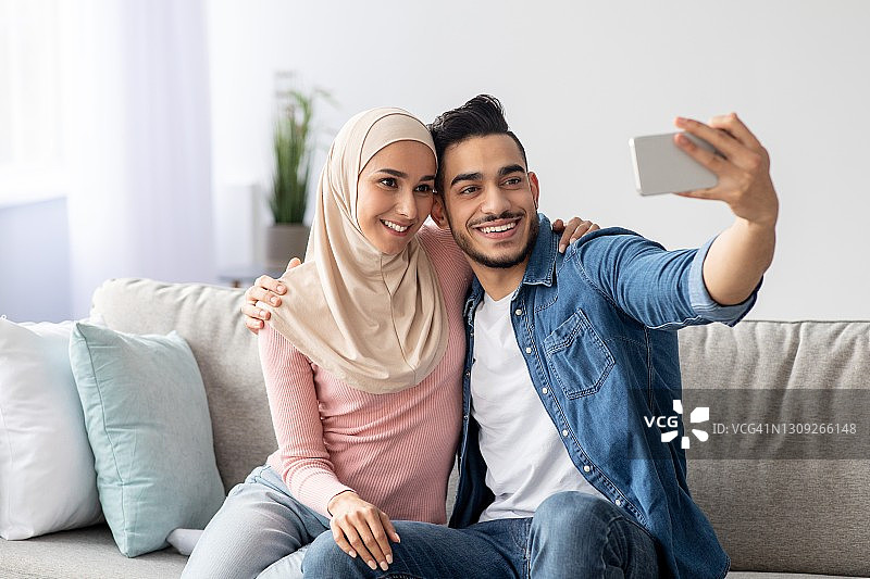 漂亮的阿拉伯夫妇在用手机自拍图片素材