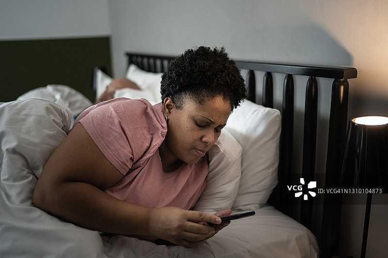 女人在床上看手机图片素材