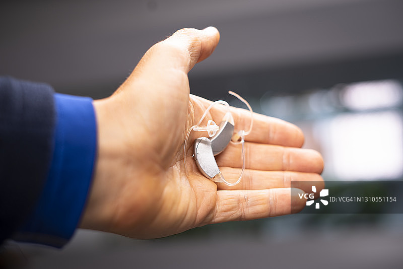 现代数字助听器在四五十岁中年人的耳朵图片素材