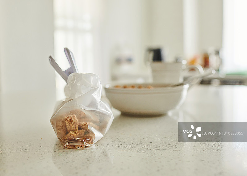亮白色的厨房柜台上放着早餐碗和一袋麦片图片素材