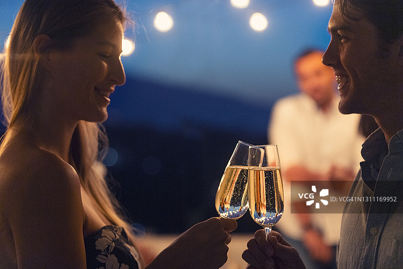 情侣们晚上用香槟祝酒。图片素材