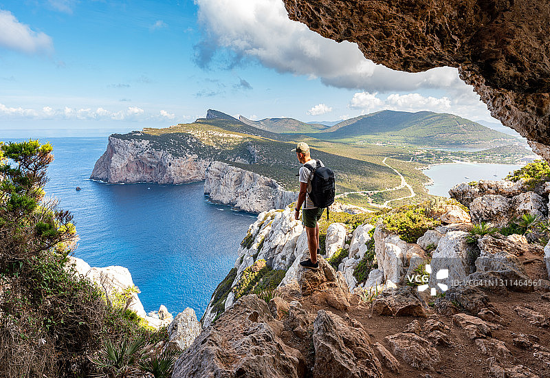 卡波·卡西亚，在山洞里欣赏风景的徒步旅行者。意大利撒丁岛图片素材