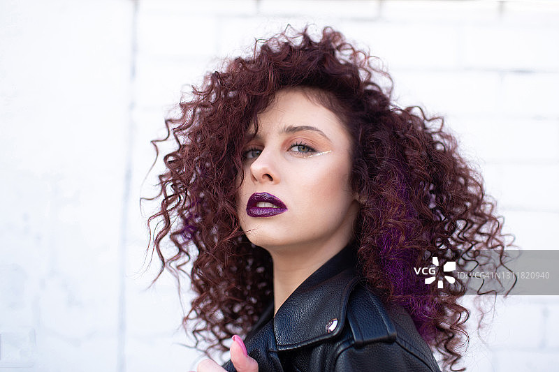 时尚少女的卷发和紫色的嘴唇摆姿势图片素材