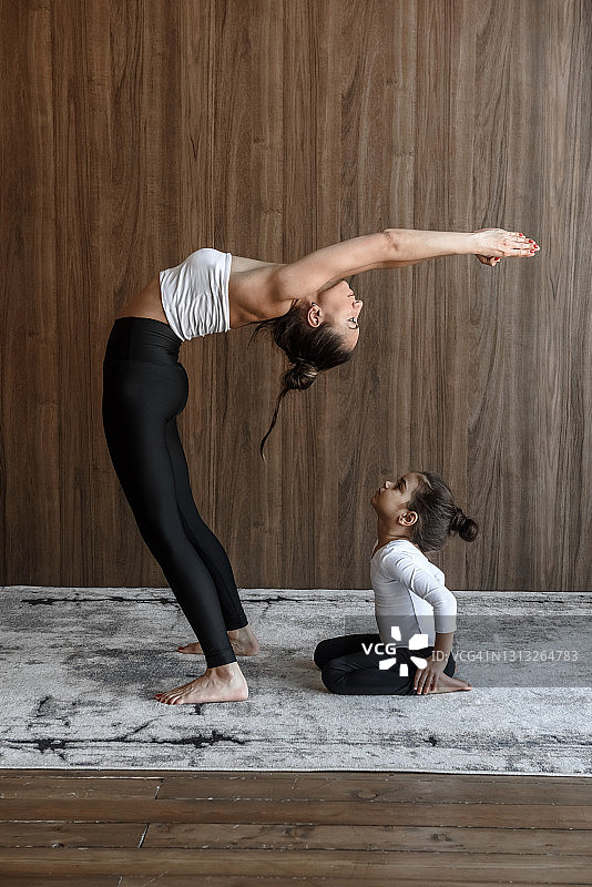 小女孩看着妈妈做运动练瑜伽伸展图片素材
