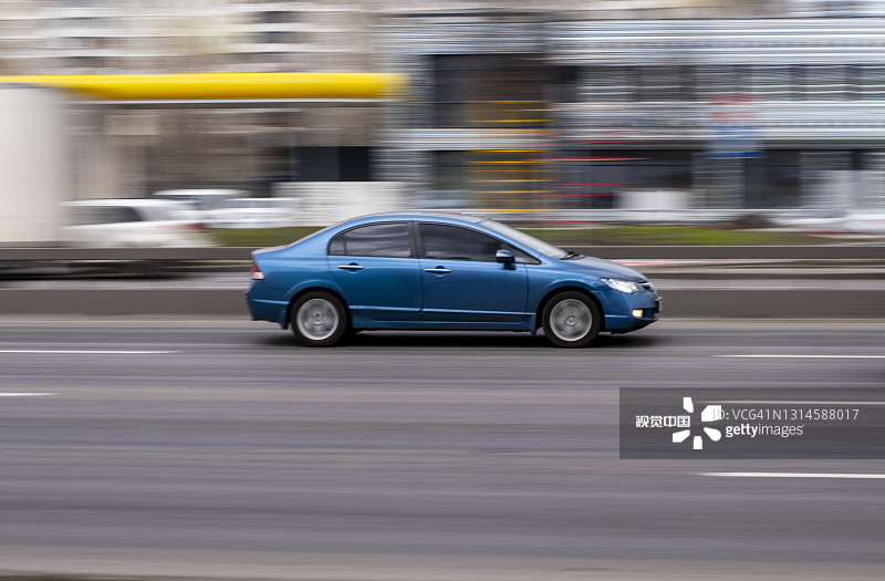 淡蓝色本田思域汽车在街道上移动。图片素材
