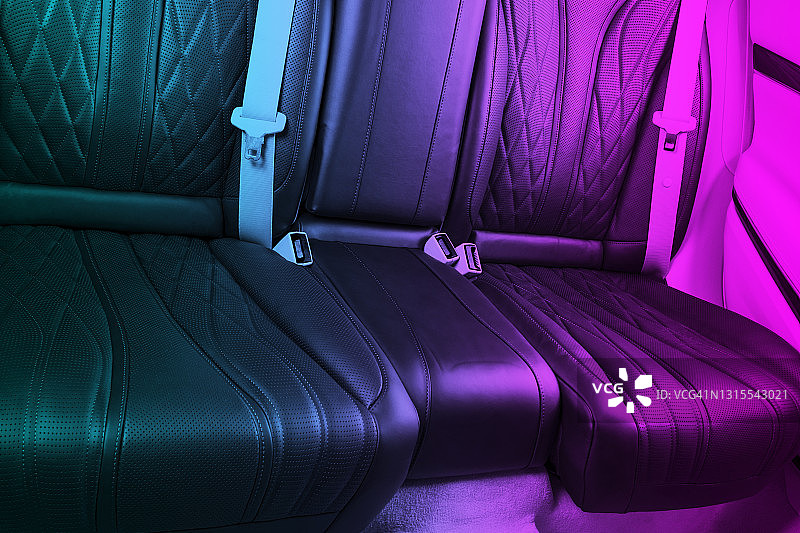 现代豪华车内。豪华现代汽车内部的蓝色和粉色调。舒适的真皮座椅。黑色穿孔皮革。乘客座位。汽车内部图片素材